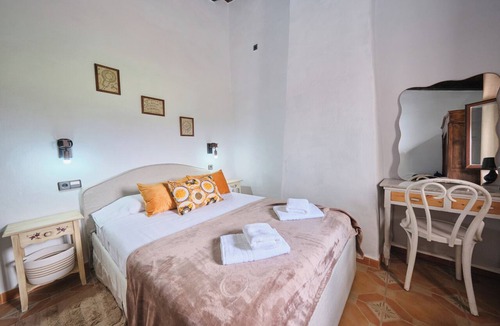 Arenas del Rey Bed & Breakfast | Luxury bedroom in Tejeda with a view of Lake Bermejales.